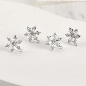 Vista macro di quattro ciondoli a fiocco di neve in argento con zirconi brillanti