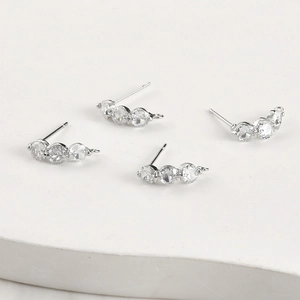 Macro view of silver curved three-zircon stud earring components for DIY jewelry making