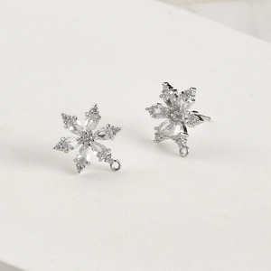 Dettaglio macro di orecchini a fiocco di neve placcati oro 14k con cristalli di zirconia