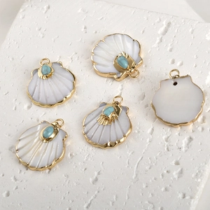 Detail of fan-shaped shell pendants with gold plating and turquoise stone inlay accents