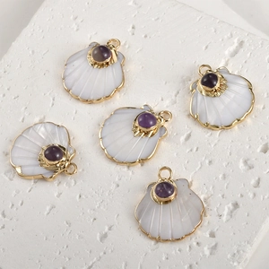 Macro detail of gold-plated fan-shaped shell pendants with purple amethyst inlay work