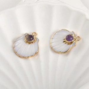 Close-up of gold-plated fan shell pendants with amethyst beads for DIY jewelry making