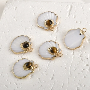 Detailed view of gold-plated shell pendants with tiger eye stone for DIY jewelry making