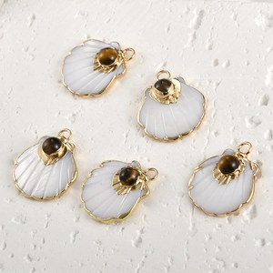 Close-up of shell fan pendants with gold plating and tiger eye stone for DIY jewelry