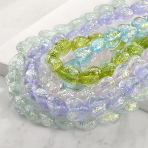 Macro shot of heart-shaped opal glass beads with gold foil for DIY jewelry making
