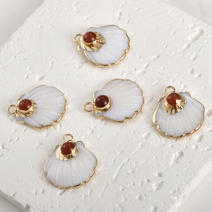 Detailed view of fan-shaped shell pendants with gold plating and red bead accents for DIY