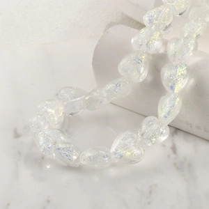 Macro shot of iridescent heart-shaped faux opal glass beads for DIY jewelry making
