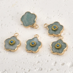 Close-up of five flower-shaped light blue natural stone pendants with gold metal edges