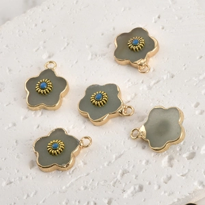 Macro detail of five petal-shaped crystal flower pendants with gold plating and blue beads