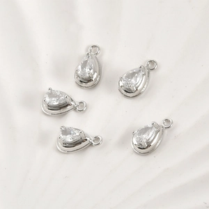 Detailed view of teardrop zircon pendants with silver metal base for jewelry making