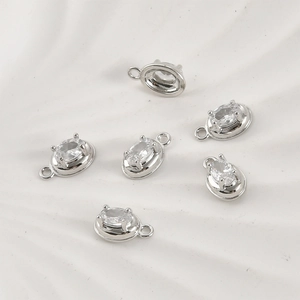 Detailed view of six silver-plated oval zircon pendants with 4-claw setting for DIY jewelry