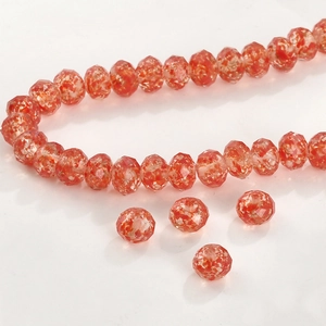 Detalle macro de cuentas facetadas naranjas con destellos dorados para joyería DIY