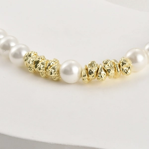 Close-up of white pearls and 14k gold-plated irregular spacer beads for jewelry making