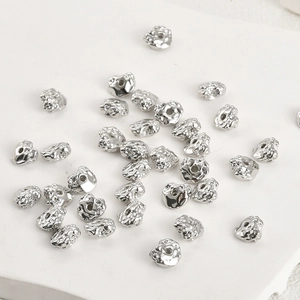 Detailed macro view of silver-plated irregular crushed stone metal spacer beads for DIY jewelry