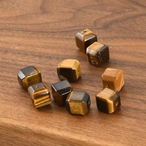 Macro view of polished cube-shaped tiger eye stone beads with natural cat-eye texture