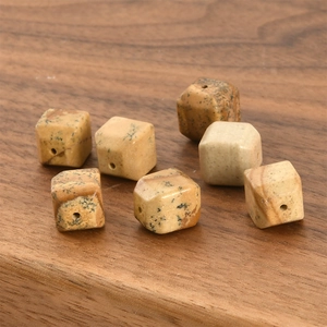 Macro shot of seven cubic natural stone beads with drill holes for DIY jewelry making