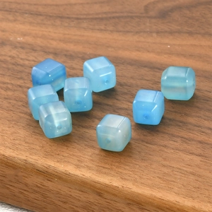 Macro shot of light blue translucent cube-shaped glass beads for DIY jewelry making