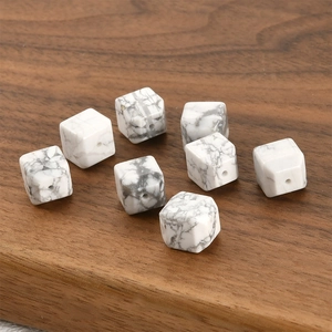 Macro detail of white howlite cube beads with grey marble texture for DIY jewelry making