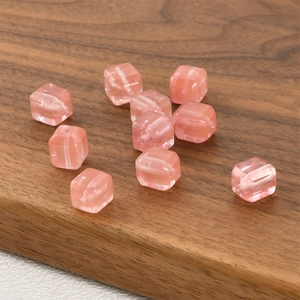 Detailed view of pink cube beads with cat eye effect and holes for jewelry making