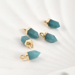 Vue macro de cinq pendentifs en cristal hexagonal avec anneaux dorés pour bijoux DIY