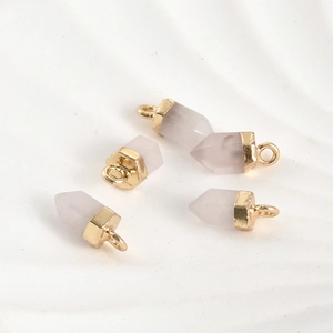 Vue macro de quatre pendentifs en quartz rose avec capuchons dorés pour bijoux DIY