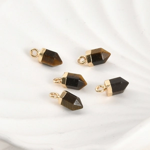 Vue macro de cinq pendentifs hexagonaux en oeil de tigre avec capuchons dorés