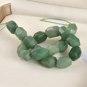 Polished green aventurine faceted beads for DIY jewelry making displayed in a soft beige box