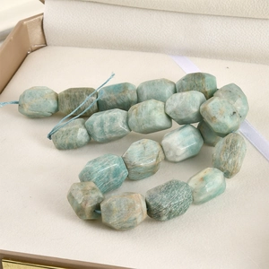 Macro detail of irregular faceted Amazonite beads in natural blue-green tones on string