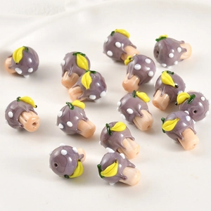 Macro detail of handmade purple glass mushroom beads with through-holes for DIY jewelry