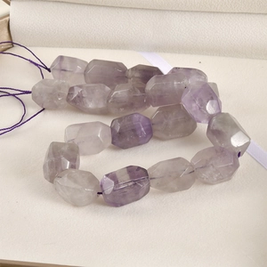 Close-up of natural purple faceted amethyst beads on a string for DIY jewelry making