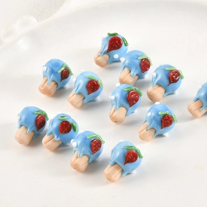 Macro shot of handmade blue cream and strawberry glass beads for DIY jewelry making