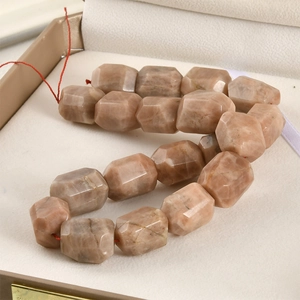 Macro view of faceted natural crystal agate beads in warm tones on velvet jewelry box