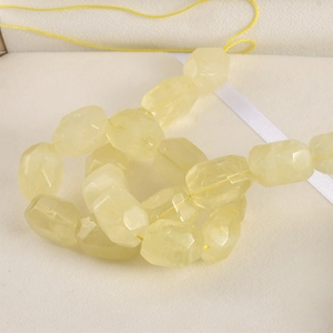 Macro shot of faceted light yellow natural crystal beads on a delicate string