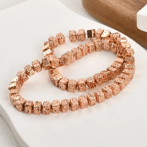 Macro-opname van 6 mm roségouden lavasteen kubuskralen voor DIY-sieraden en armbanden