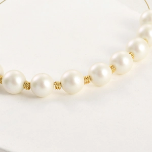 Primer plano de perlas blancas con cuentas espaciadoras trenzadas en oro de 14k para joyería