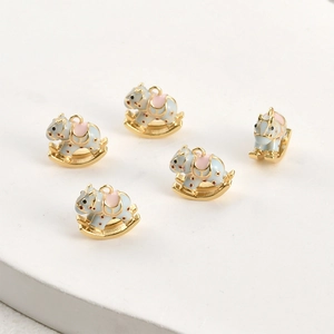 Detailaufnahme von 5 blau-rosa Schaukelpferd-Anhängern, 18k vergoldet für DIY-Schmuck