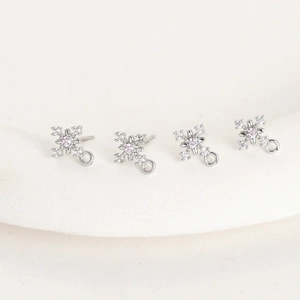 Detailed view of silver snowflake earring posts with pink zircon for DIY jewelry making