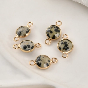 Macro detail of five gold-plated dalmatian jasper stone connectors for DIY jewelry
