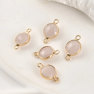 Detailed view of five pink crystal pendants with gold plated edges for DIY jewelry making