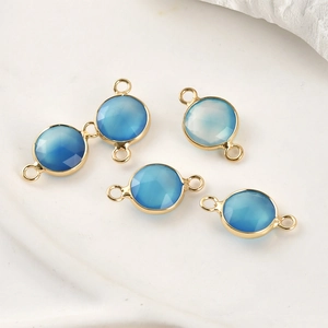 Detailed view of five blue faceted gemstone connectors with gold plated circular frames