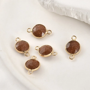 Macro shot of 5 faceted goldstone pendants with gold plated edges for DIY jewelry making