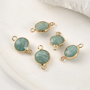 Detail view of gold-plated green amazonite connector pendants with double rings for DIY jewelry