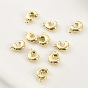 Vista macro di ciondoli a forma di C placcati in oro 14k per gioielli fai da te