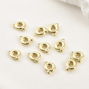 Dettaglio macro di 10 ciondoli lettera Q lucidi placcati in oro 14k per gioielli DIY