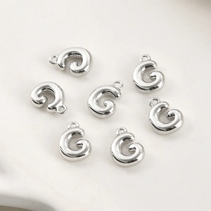Vista macro di sette ciondoli a spirale in argento lucido per la creazione di gioielli