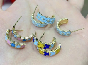 Vintage enamel C-shaped hoop earrings featuring colorful star and butterfly motifs