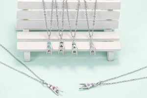 Detail of silver rock hand gesture pendants with colorful gemstones on a mint background