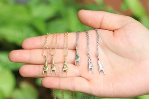 Detail of colorful hand gesture necklaces with zircon stones on gold and silver chains