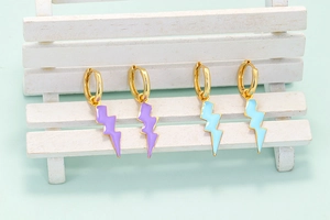 Detalle de pendientes de rayo en esmalte lavanda y azul claro sobre una silla miniatura
