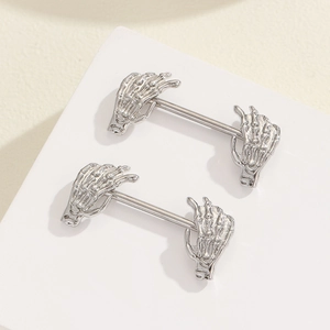 Detailed macro view of silver gothic skeleton hand nipple rings made of stainless steel